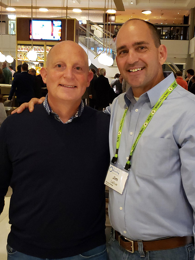 Two men standing next to each other in a room.